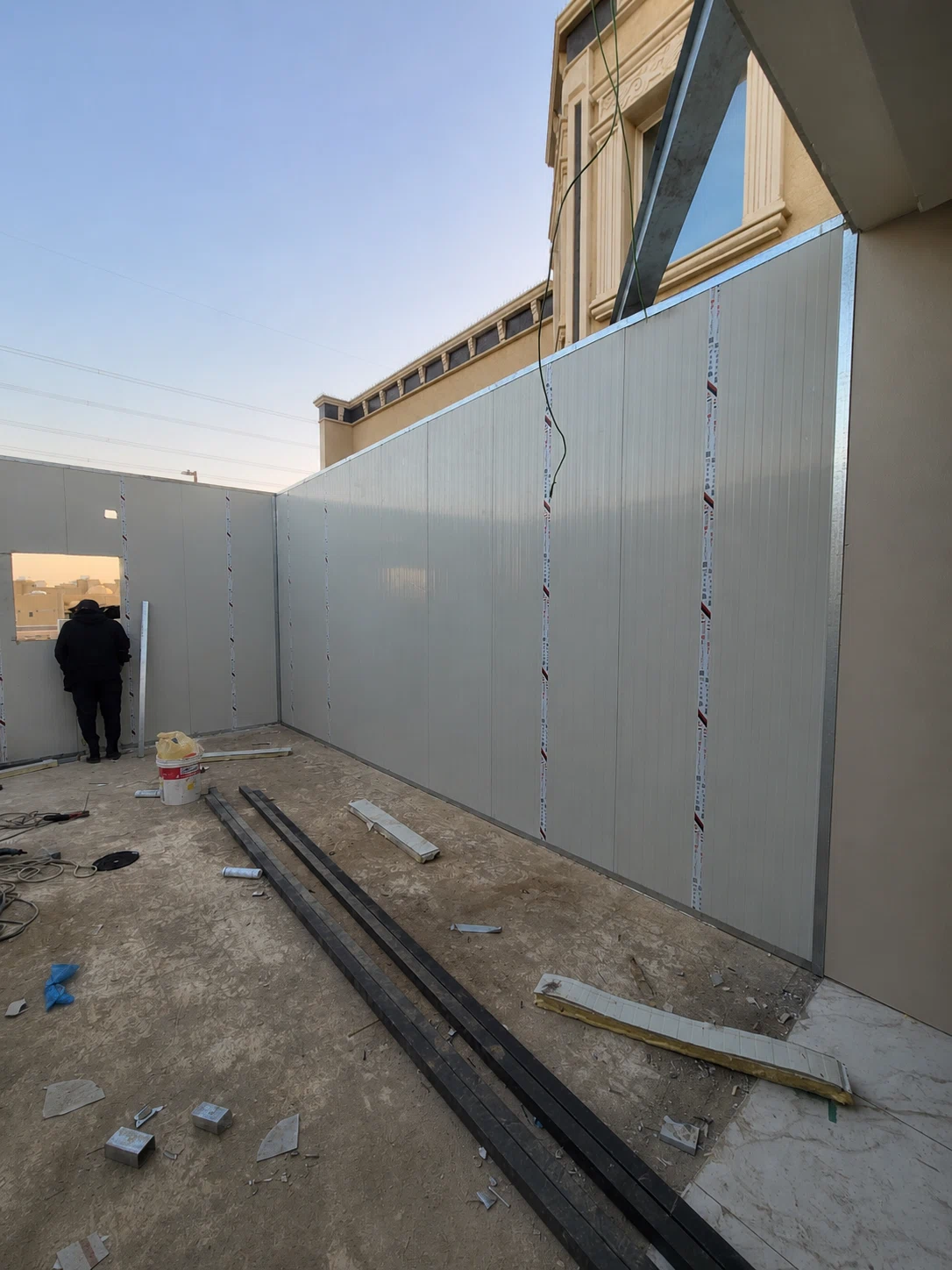تركيب جدران ساندوتش بانل في موقع إنشائي بالرياض مع ألواح معزولة وهيكل معدني لتجهيز غرفة أو ملحق